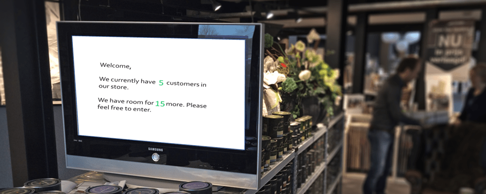 Un moniteur affichant un message en direct sur le nombre de clients dans le magasin, alimenté par REST-API, dans un magasin.