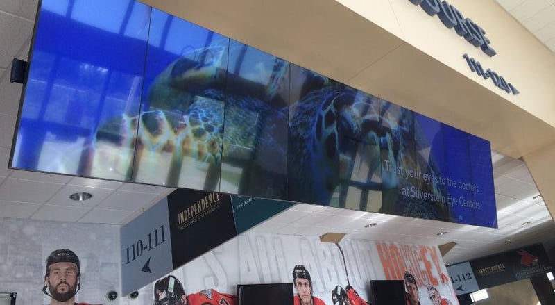 Mur vidéo suspendu dans une arène de la LNH affichant une publicité pour les Silverstein Eye Centers.