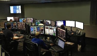 Une salle de contrôle avec des travailleurs à leurs postes de travail