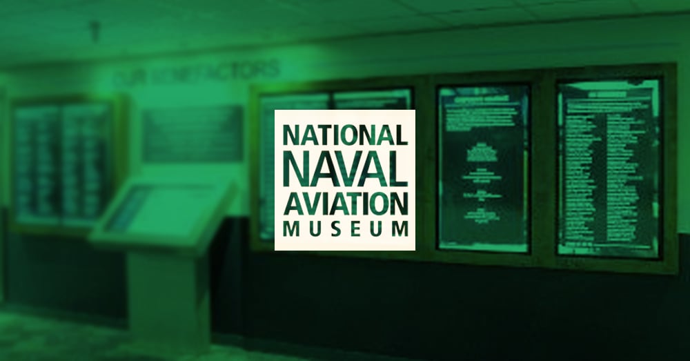 Hall de reconnaissance vide du Musée national de l'aviation navale, avec des murs vidéo pour l'affichage de la reconnaissance des donateurs avec une superposition verte et un logo.