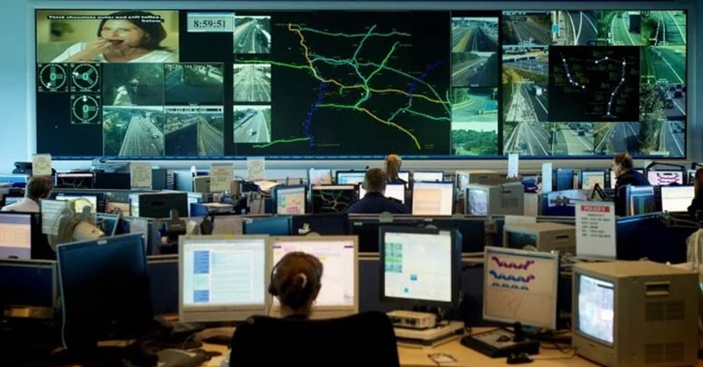 Centre des opérations d'urgence, avec des murs vidéo affichant des caméras de circulation et des itinéraires en direct, et des employés travaillant à des postes de travail.