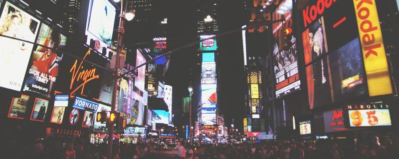 Le Times Square de New York est rempli de murs vidéo et de panneaux numériques, et de nombreuses personnes la nuit.