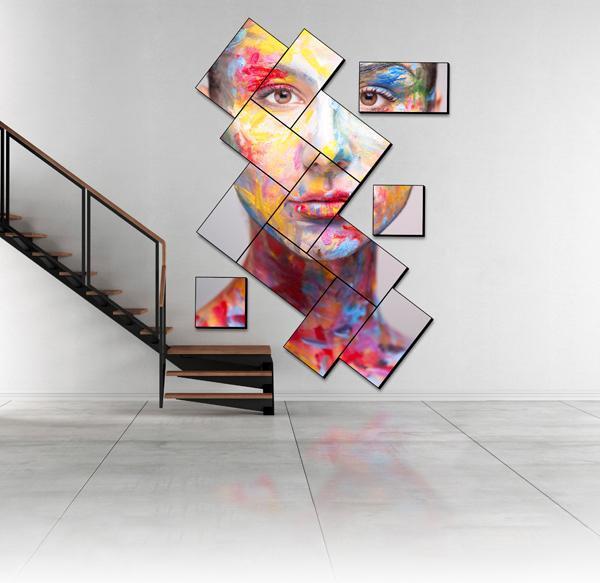 Un escalier moderne et un mur vidéo en mosaïque artistique présentant une œuvre d'art représentant un visage peint.