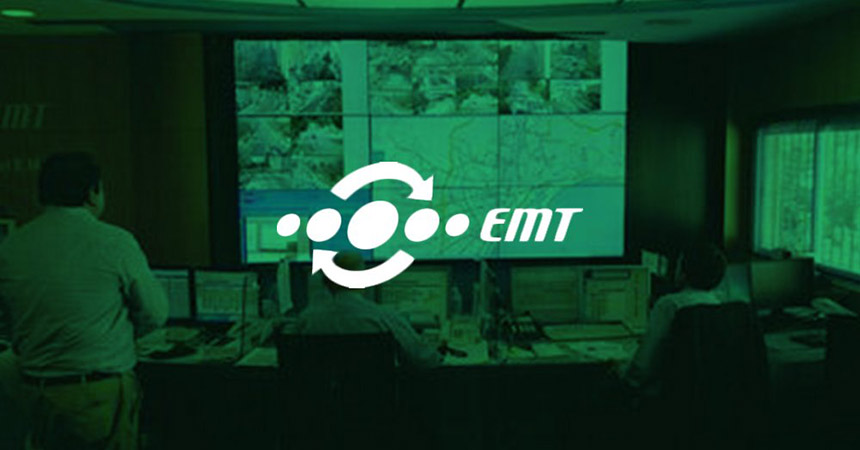 Les employés de l'EMT surveillent les opérations de transport en commun à partir de leur poste de travail et d'un mur vidéo affichant des images en direct, des cartes de transport en commun et des sites Web avec une superposition verte et un logo.