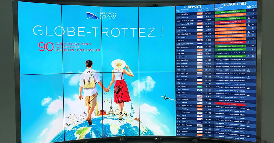Mur vidéo à l'aéroport de Toulouse-Blagnac affichant la publicité et les heures de départ des vols